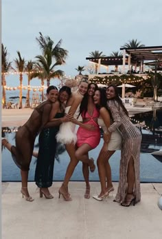 four women posing for a photo in front of a pool