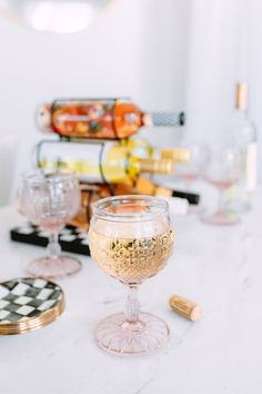 there is a wine glass on the table next to some other glasses and corks