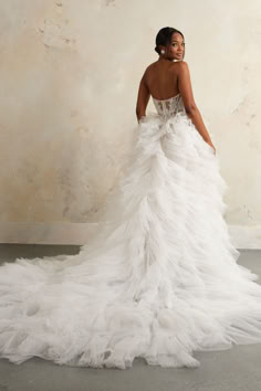 a woman in a white wedding dress posing for the camera