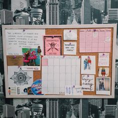 a bulletin board with pictures and post it notes attached to the wall in front of a cityscape