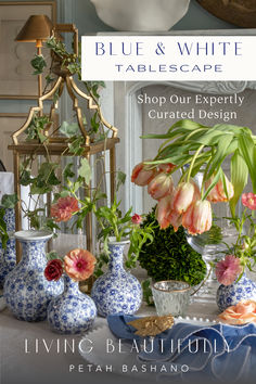 A summer dining table with blue & white flower vases set at the table's centerpiece with simple gold metal lanterns, candleholders, plates in white with pearl band and blue and white napkins and a gold tobacco leaf napkin ring. Flower vases in a clear glass urn holds peach parrot tulips with a boxwood accessory ball at the back of the design. Blue And White Table Setting, White Table Setting, Dining Room Decor Traditional, White Tablescape, Blue Fall Decor, Summer Table Settings, Simple Table Settings, Unique Glassware, Baby Shower Yellow