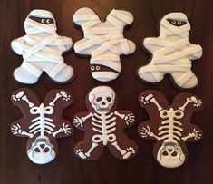 decorated cookies with white icing and skeleton decorations on a wooden table, top view