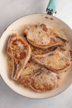 some meat is cooking in a pan on the table