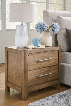 a living room with a couch and two vases on the end table next to each other