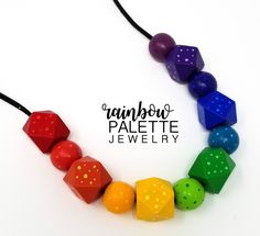 a necklace made out of different colored plastic cubes on a black cord with the words rainbow palette jewelry written below it