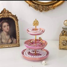 three tiered tray with pearls and a painting on the wall