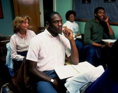 a group of people sitting around each other talking on cell phones