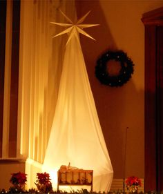 a nativity scene with a star above the crib and wreath on the wall