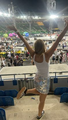 a woman jumping in the air with her arms wide open at a sporting event,