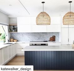 a large kitchen with white cabinets and black counter tops is featured in the magazine kate walker design