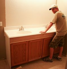 a man standing in front of a bathroom sink