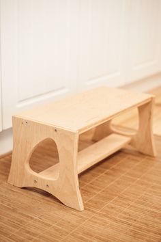 a wooden bench sitting on top of a hard wood floor