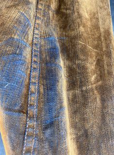 a person with their foot on the ground next to a skateboard and some jeans