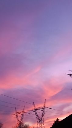 some power lines are silhouetted against a purple sky