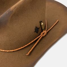 Designed in collaboration with bespoke hat-makers Coup de Tete, this classic cowboy hat is as handcrafted as they come. Flame-distressed texture and scorched hot-knife detailing complement the bullet hole that pierces through the hat's brim and crown. A bullet casing sits beside our monogram, which has been branded into the fur felt exterior. The woven leather detailing and co-branded leather inner band serve as the finishing touches on a hat that is designed to last a lifetime. Small: 7 1/4 (58 Bullet Hole, Bespoke Hats, Classic Cowboy, Bullet Casing, Leather Detailing, Distressed Texture, Bone White, Instagram Design, Cowboy Hat