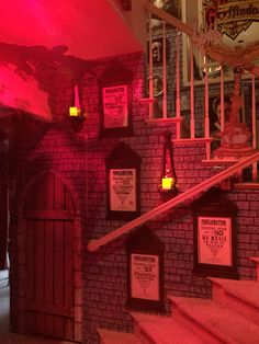 the stairs are lit up with red lights and posters on them in front of a brick wall