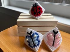 two small crocheted items sitting on top of a wooden table next to a window