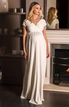 Sleek and elegant, our Francesca Wedding Gown in dreamy ivory white glides over your pregnancy curves in luxurious soft-sheen jersey. With a crossover neckline and grow-on sleeves that can be worn on or off-the-shoulder, this maternity dress fits and flatters in all the right places. Ivory white luxe jersey with subtle sheen Flattering cross-over neckline Stretch for comfort Floaty full-length skirt Fully lined Perfect for all stages of pregnancy Made in Britain Luxury Fitted Maternity Maxi Dress, Luxury Wedding Dresses With Subtle Sheen, Maternity Evening Gowns Tiffany Rose Maternity, Luxury Cream Elegant Evening Dress, Luxury Full-length Sleek Maxi Dress, Luxury Sleek Black Maxi Skirt, 4 Months Pregnant Elopement White Dress, Maternity Marriage Dresses, Maternity Wedding Dresses Tiffany Rose Maternity