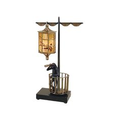 a lamp that is on top of a stand with a dog in the cage next to it