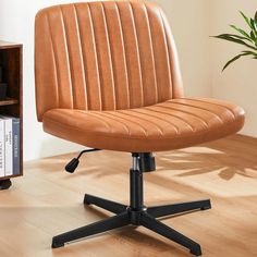 a brown office chair sitting on top of a hard wood floor next to a book shelf