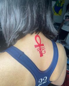 the back of a woman's neck with a red ribbon on her left shoulder