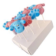 there are many blue and pink cake pops with faces on them in the shape of elephants