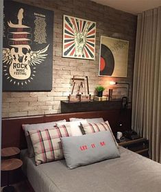 a bedroom with brick walls and posters on the wall above the bed, along with two side tables