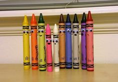 crayons with faces drawn on them are lined up in a row next to each other