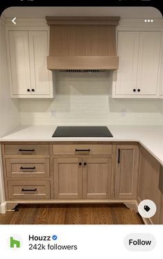 a kitchen with white cabinets and wood floors