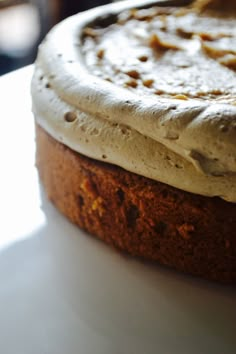 a cake with white frosting sitting on top of a table