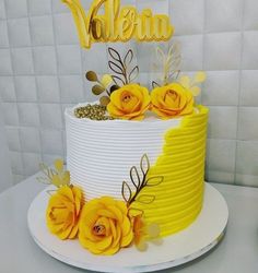 a yellow and white cake with flowers on top