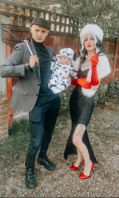 a man and woman dressed up as the addams with a baby in their arms