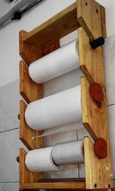 a wooden rack holding several rolls of white fabric