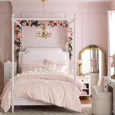 a bedroom with pink walls, white bedding and floral decorations on the headboard