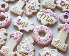 decorated cookies with the number one and two for first birthdays are arranged on a table