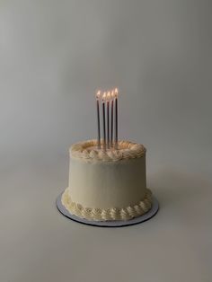 a white cake with five candles on it