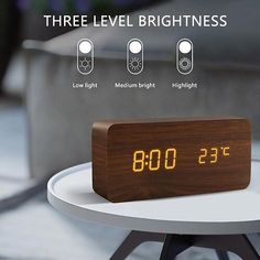 an alarm clock sitting on top of a table next to a coffee table with three levels