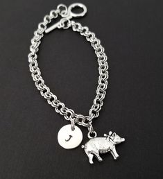 Personalized Antique Silver Pig Bracelet!  A sweet pig charm on a lovely chain bracelet makes the perfect gift for you or your best friend.The pig bracelet charm is made from zinc alloy and measures 15 mm by 21 mm.  The bracelet is high quality zinc alloy and measures 8.5".  The pig bracelet can be personalized with a .5" silver plated disc stamped with the initial of your choice.  The charm and initial disc are connected to the bracelet with sturdy split rings that will never fall off!  You can Gold Sheep Bracelet, Personalized Pink Novelty Charm Bracelet, Pig Bracelet, Keychain Pig, Pig Necklace, Animal Bracelet, Split Rings, Initial Bracelet, Personalized Bracelets