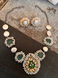 The short necklace is beautifully handcrafted in sea green stones with pearl clusters and coin pearls. Diameter of studs: 2.5 cms The Paan-shaped centerpiece is embellished with Kundan stones. The statement baroque pearl studs add to the glamour of the designer necklace. Material: Brass with dual tone polish Pearl Cluster, Coin Pearls, Kundan Jewellery, Sea Green, Indian Jewellery, Short Necklace, Green Stone, Pearl Studs, Designer Wear