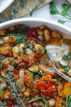 a white bowl filled with beans and vegetables