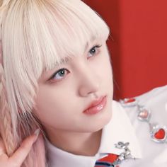 a woman with blonde hair wearing a white shirt and red tie, posing for the camera