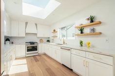 a kitchen with white cabinets and wooden floors