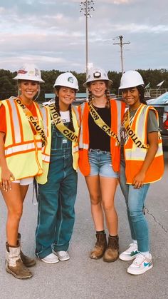 three girls in safety vests and hard hats posing for the camera with each other