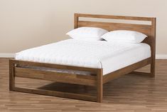 a wooden bed frame with white pillows on top of it and wood flooring in the background