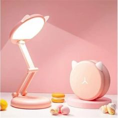 a pink desk lamp sitting on top of a table