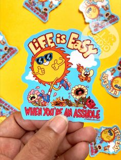 someone holding up a sticker that says life is easy when you're an assholle