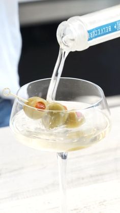 a glass filled with white wine and olives