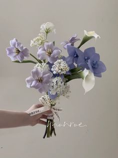 a person holding a bouquet of flowers in their hand with the word love written on it