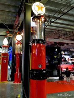 the inside of a car showroom with red and black booths, lights, and signs