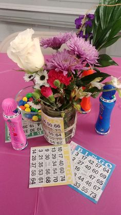 a vase filled with lots of flowers on top of a pink table covered in numbers